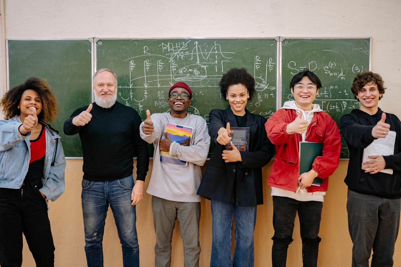 high school students with math teacher in front of chalk board
